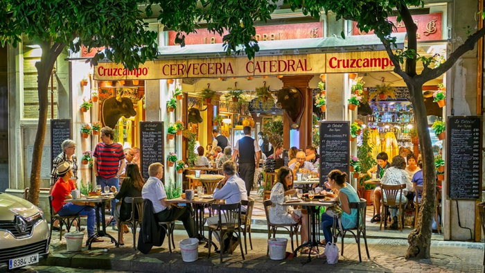 Outdoor diners at night at the Bar Cerveceria Catedral, near Seville Cathedral, Spain