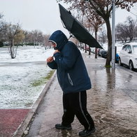 Man in snow and wind with umbrella inside out