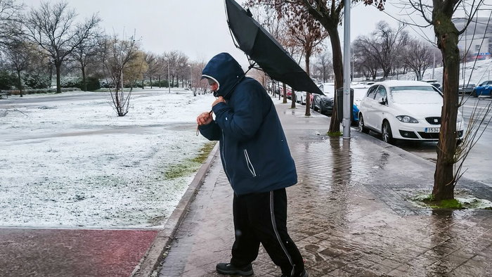 Man in snow and wind with umbrella inside out