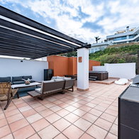 Luxury outdoor terrace in Spain with a jacuzzi and outdoor furniture in the corner