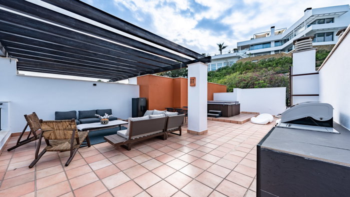 Luxury outdoor terrace in Spain with a jacuzzi and outdoor furniture in the corner