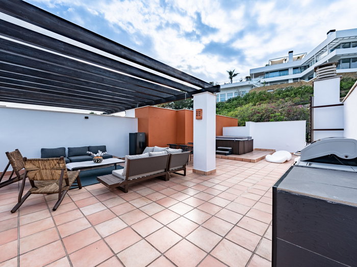 Luxury outdoor terrace in Spain with a jacuzzi and outdoor furniture in the corner