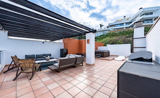 Luxury outdoor terrace in Spain with a jacuzzi and outdoor furniture in the corner