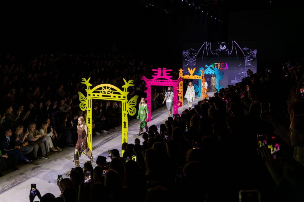 Models from Moscow Fashion week on runway walking through different coloured archways