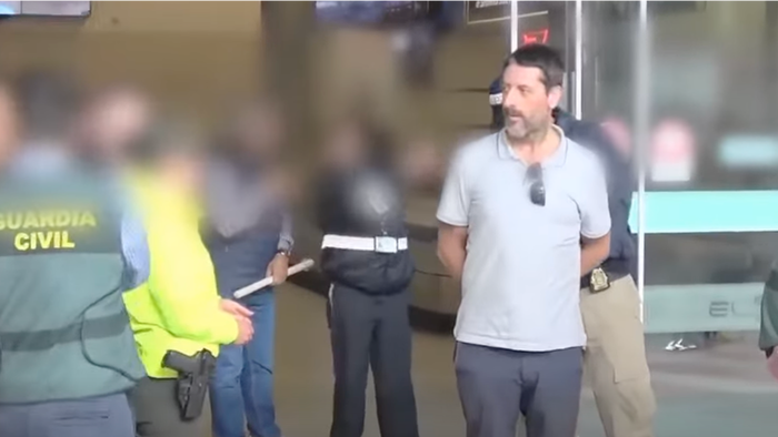 An image of Carlos García Roldán handcuffed and being escorted by police during his arrest in 2019.