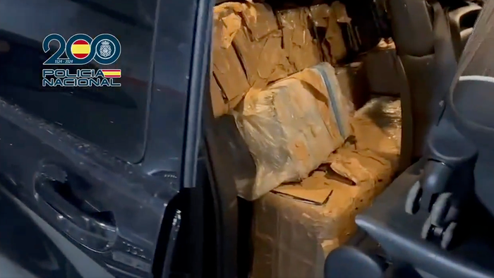 Bundles of cocaine wrapped in tape and stacked inside a car seat, photographed by Policía Nacional during a drugs raid.
