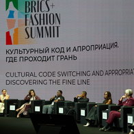 View of the stage at the Fashion summit with the speakers sat on the stage