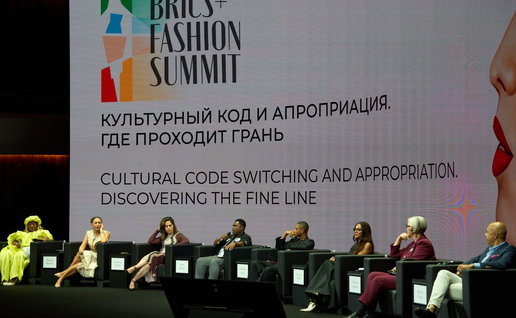View of the stage at the Fashion summit with the speakers sat on the stage