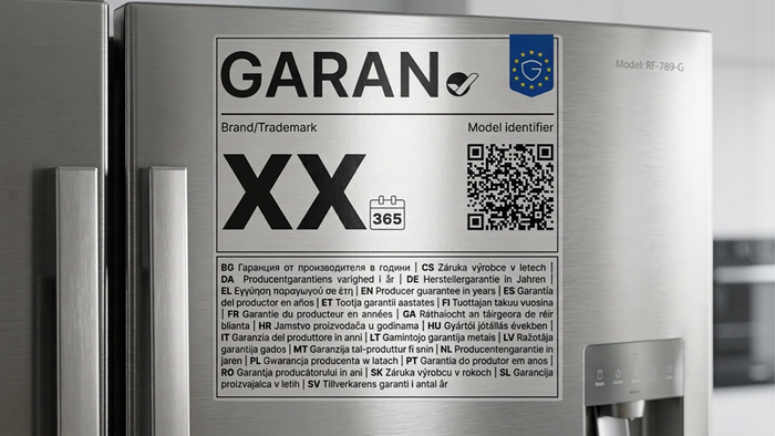 Close-up of the new EU GARAN guarantee label on a fridge door, showing the tick symbol, QR code and guarantee-length information in multiple languages.