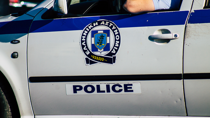 A Greek Police patrol car, with an officer resting his arm on the open window.