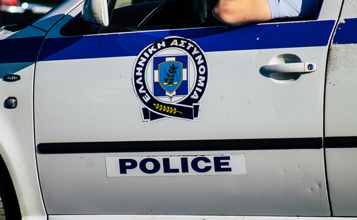 A Greek Police patrol car, with an officer resting his arm on the open window.