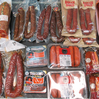 A shelf of vacuum-packed chorizo, sobrasada, fuet and other cured meats and sausages.