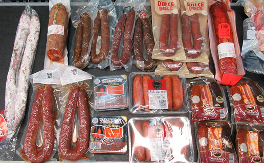 A shelf of vacuum-packed chorizo, sobrasada, fuet and other cured meats and sausages.