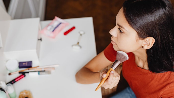 Young female applying makeup