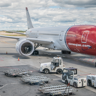 Norwegian aircraft parked at a terminal outside the Oslo Gardermoen airport.