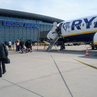 Ryanair aircraft at Rzeszów Airport in Poland as passengers board and walk across the airport tarmac.