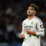 Raúl Asencio running during a football match wearing his Real Madrid football jersey.