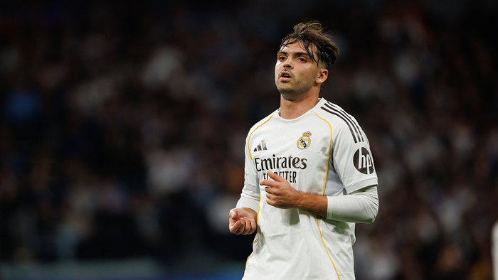 Raúl Asencio running during a football match wearing his Real Madrid football jersey.