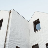 A modern white colored architecture low angle shot with a clear white sky