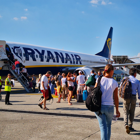 A Ryanair aircraft on the tarmac as passengers make their way on to the airplane.