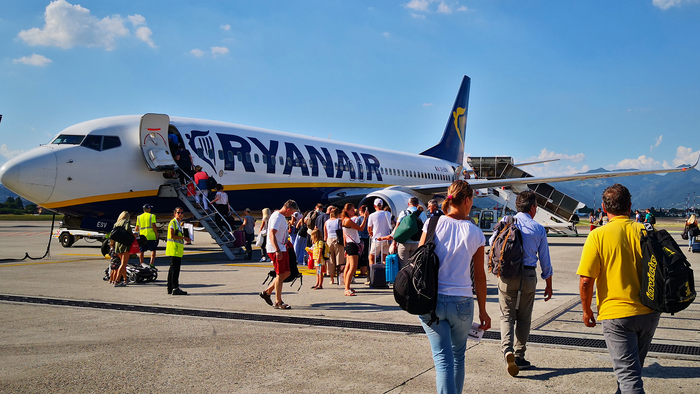 A Ryanair aircraft on the tarmac as passengers make their way on to the airplane.