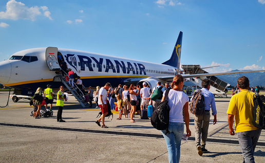 A Ryanair aircraft on the tarmac as passengers make their way on to the airplane.