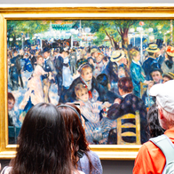 Tourists looking at a framed painting of Renoir