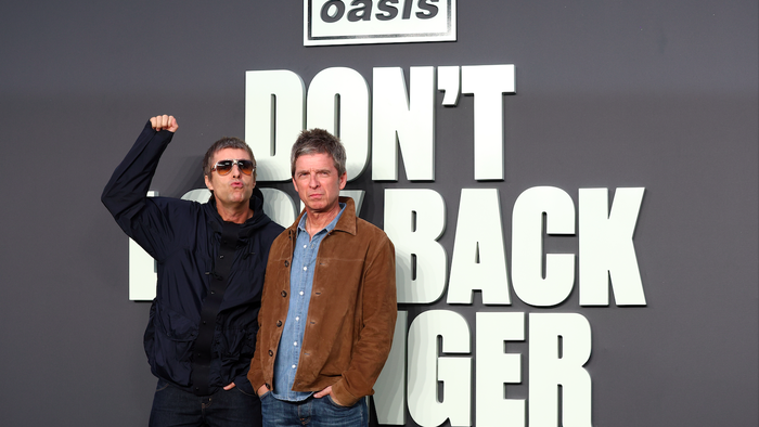 The Gallagher brothers that for the band Oasis behind a logo that reads ''Don't look back in anger''