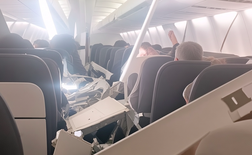 Airplane cabin interior with collapsed white plastic ceiling panels resting on seats and passengers.