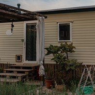 A mobile home with pergola and plants at the entrance