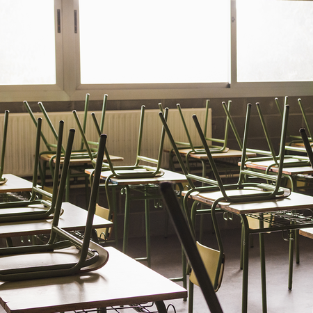 Chairs stacked on tables in a Spanish classroom.