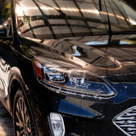 Dark car getting washed with soap and water