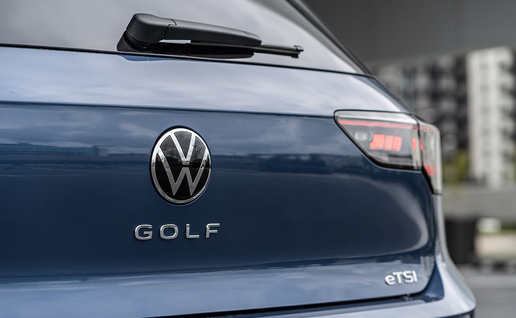 Close-up of the rear badge and taillight of a dark blue Volkswagen Golf.