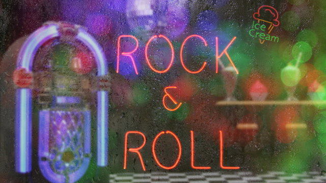 Jukebox in a bar with neon sign Rock n Roll with rainy window