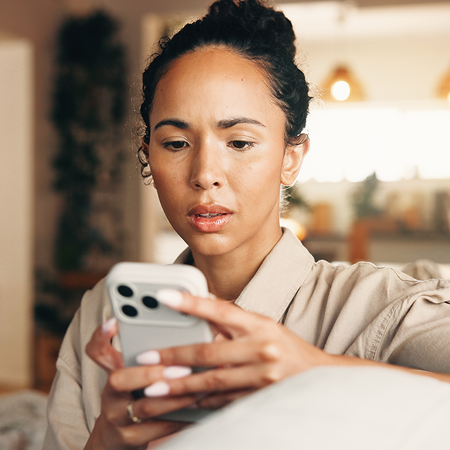 Woman looks worrying at her phone.