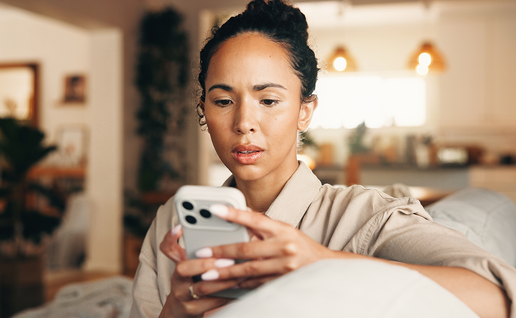 Woman looks worrying at her phone.