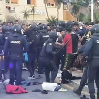Spanish National Police officers intervene as a large crowd gathers during the Ceuta camp operation.