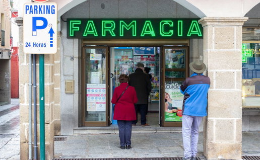 Senior patients waiting outside a Spanish pharmacy ("Farmacia") storefront with a green glowing sign, illustrating prescription management and community health care.