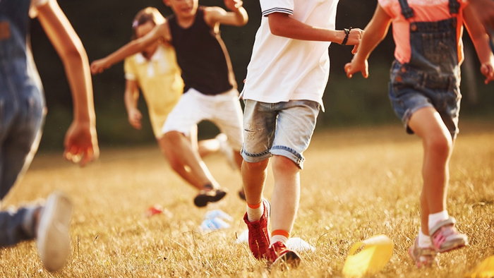 Kids running in the field at sunny day.