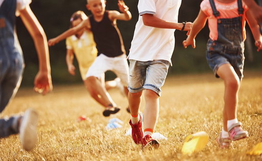 Kids running in the field at sunny day.