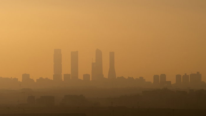 View of Madrid Business Area skyscrapers with air pollution during sunset