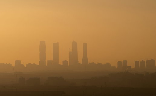 View of Madrid Business Area skyscrapers with air pollution during sunset