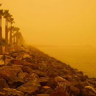 Yellow skies from Saharan dust on a beach front