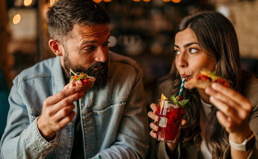 Young couple sharing tapas and drinks, enjoying a date night out