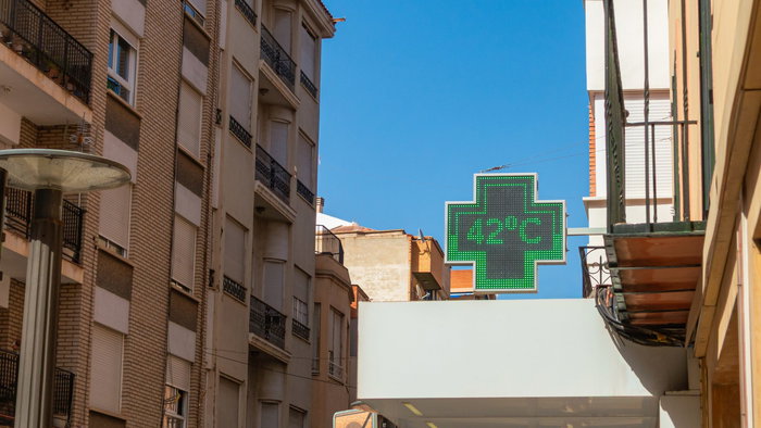 Green cross thermometer above a pharmacy in Spain indicating 42º