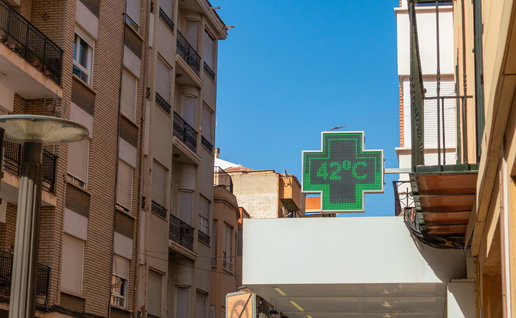 Green cross thermometer above a pharmacy in Spain indicating 42º