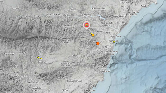 Relief map of eastern Almería province with coloured circles marking earthquake epicentres, including a red target symbol north of Lubrín and orange circles near Bédar