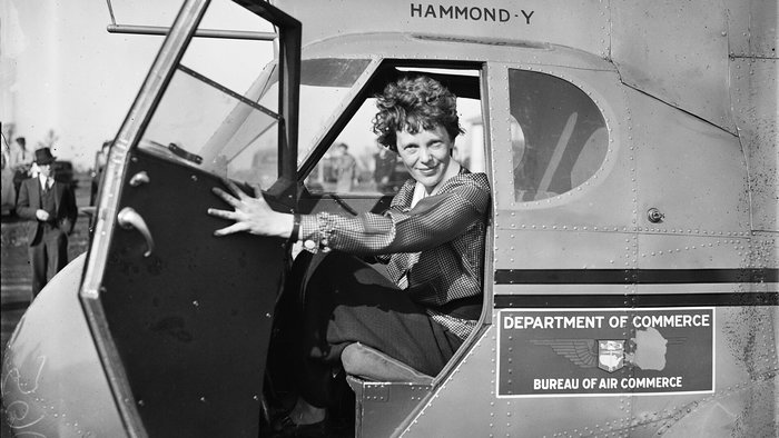 Amelia Earhart sitting in the cockpit of an aircraft