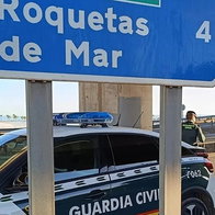 Guardia Civil officers next to Roquetas de Mar sign