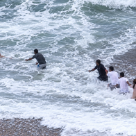 Passersby race to rescue of woman washed out to sea.